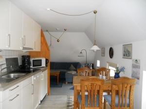 uma cozinha e sala de estar com mesa e cadeiras em Ole in Borgsum em Borgsum