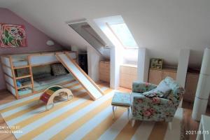 a attic room with a couch and a chair and a bed at Family house by the Sziget festival in Budapest