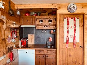 een keuken met houten kasten en een wastafel bij Studio Les Arcs 1600, 1 pièce, 3 personnes - FR-1-411-468 in Arc 1600