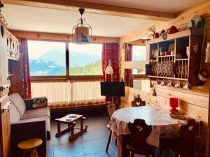 uma sala de estar com uma mesa e uma grande janela em Studio Les Arcs 1600, 1 pièce, 3 personnes - FR-1-411-468 em Arc 1600