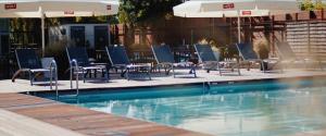 a pool with chairs and tables and an umbrella at Maloves Resort & Spa in Władysławowo