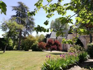 a house with a lawn and flowers at Les INSOLITES DE LA TOUCHE in Azay-le-Rideau