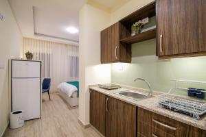 a kitchen with a sink and a refrigerator at 46 Serviced Apartments in Amman