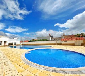 uma grande piscina azul num pátio em ROOM 335 em São Martinho do Porto