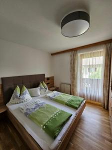 リエンツにあるFerienwohnungen Haus Schettのベッドルーム1室(大型ベッド1台、緑のシーツ付)