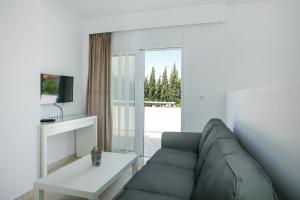 a living room with a couch and a table at VOULA APARTMENTS in Faliraki