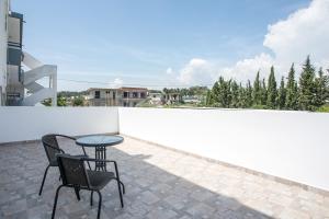 patio z 2 krzesłami i stołem na balkonie w obiekcie VOULA APARTMENTS w mieście Faliraki