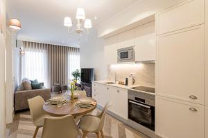 a kitchen and living room with a table and chairs at 19 Nineteen Suites - Espinho in Espinho