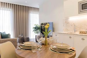 a kitchen with a table with plates and wine glasses at 19 Nineteen Suites - Espinho in Espinho