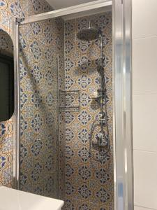 y baño con ducha y azulejos azules y blancos. en Cozy 2 bedroom Apartment near Seafront en Il-Gżira