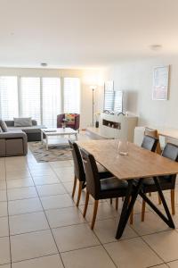 uma sala de estar com uma mesa de madeira e cadeiras em Los Lorentes Residences Bulle - Hine Adon em Bulle