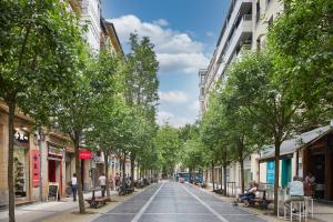 a tree lined street in a city with buildings at Elkano by FeelFree Rentals in San Sebastián