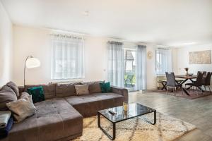 una sala de estar con un sofá y una mesa en Tulips Apartment, en Meckenbeuren