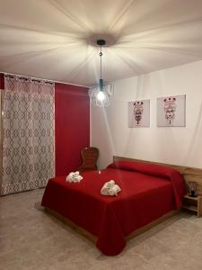 um quarto com uma cama vermelha com dois bichos de peluche em Casa Vacanza Sicily House em Gaggi