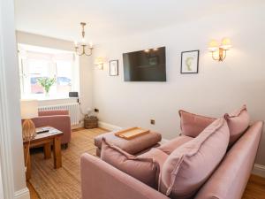 a living room with a couch and a tv at Keepers Cottage in York