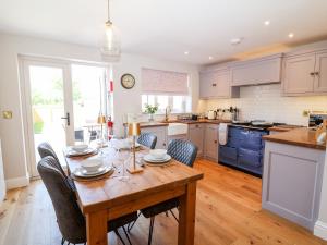 a kitchen with a wooden table with chairs around it at Keepers Cottage in York