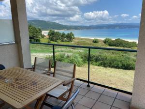 - Balcón con mesa y sillas y vistas al lago en apartamentos beach langosteira 2 en Finisterre