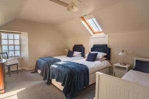 two beds in a room with two windows at John McDouall Stuart View in Dysart