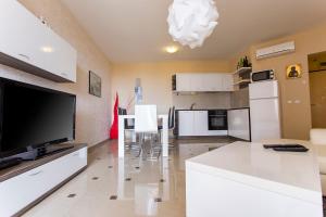 ソゾポルにあるApartments Sozopoli Hillsのリビングルーム(大画面テレビ付)、キッチンが備わります。