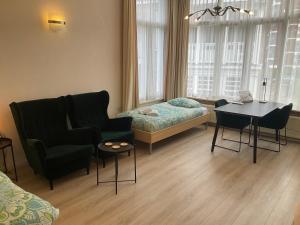 - un salon avec un canapé, un lit et une table dans l'établissement Plato by Hofstad Studio’s, à Scheveningen