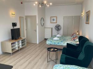 ein Schlafzimmer mit einem Bett, einem Sofa und einem TV in der Unterkunft Plato by Hofstad Studio’s in Scheveningen