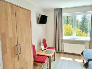 Zimmer mit einem Tisch, 2 Stühlen und einem Bett in der Unterkunft AM BERG Hotel in Herzberg am Harz