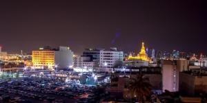 een skyline van de stad 's nachts met veel verkeer bij Doha Dynasty Hotel in Doha