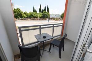 a balcony with a table and chairs and a view of a street at Miro Apartment in Rovinj