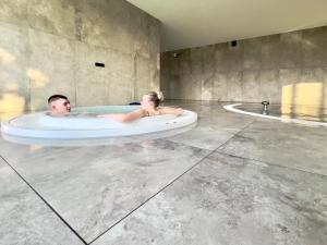 a man and a woman laying in a bath tub at Apartament Superior & SPA Marina Dziwnów in Dziwnów +21 photos