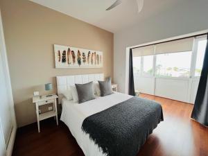 1 dormitorio con cama y ventana grande en Casa Lola en Costa Teguise