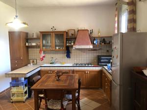 una cocina con una mesa y un refrigerador en VILLA MICHELA, en Plemmirio