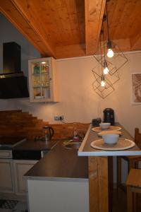 uma cozinha com um balcão com um lavatório e uma bancada em maison de bourg en pierre em Saint-Maurice