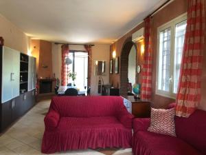 sala de estar con sofá rojo y ventanas en VILLA MICHELA, en Plemmirio