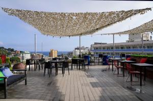 a patio with tables and chairs on a roof at BPM Lloret Hotel in Lloret de Mar