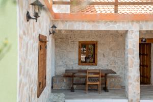 a wooden table on a stone wall with a wooden chair at Villa Mramor in Neum