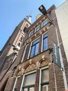 un edificio con un letrero de la calle delante de él en Boutiquehotel The Church en Arnhem