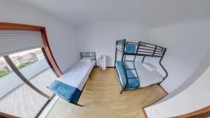 2 Etagenbetten in einem Zimmer mit Fenster in der Unterkunft We Are Hostel 2 in Póvoa de Varzim