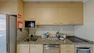 a kitchen with wooden cabinets and a counter top at We Are Hostel 2 in Póvoa de Varzim +35 photos