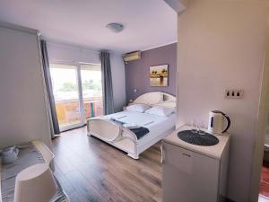 1 dormitorio con cama blanca y balcón en Apartments Melita, en Supetarska Draga