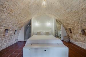 ein Schlafzimmer mit einem Bett in einer Steinmauer in der Unterkunft Dimora Rutica in Selva di Fasano