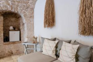 ein Wohnzimmer mit einem Sofa und einer Steinmauer in der Unterkunft Dimora Rutica in Selva di Fasano