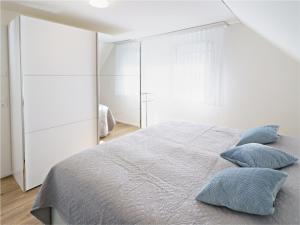 Exklusive 4.5 Zimmer Wohnung für Familien und Business في Eschenz: غرفة نوم عليها سرير ومخدات زرقاء