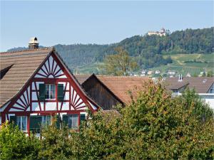 una casa rossa e bianca con una montagna sullo sfondo di Exklusive 4.5 Zimmer Wohnung für Familien und Business a Eschenz