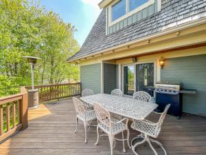 麦克亨利Luxury Stunning Mountaintop Home with Hot Tub and Lake Views的露台上有一张桌子和几把椅子