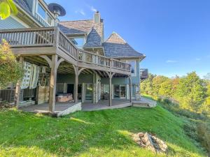 麦克亨利Luxury Stunning Mountaintop Home with Hot Tub and Lake Views的草坪上带甲板的大房子