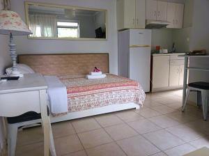 Cet appartement comprend une chambre avec un lit et une table ainsi qu'une cuisine. dans l'établissement Villa Thassos Paradise, à Thasos