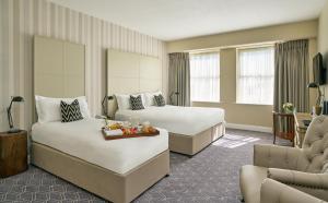 a hotel room with two beds and a couch at Summerhill House Hotel in Enniskerry