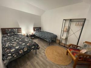 ein Schlafzimmer mit einem Bett, einem Stuhl und einem Spiegel in der Unterkunft Maison complète Normandie proche Giverny in Vernon