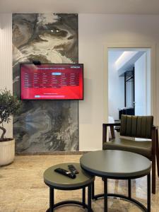 Olivea Apartments في فيليبوجي: غرفة مع طاولة وكرسي وتلفزيون
