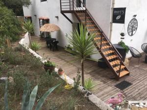 a wooden deck with a staircase next to a building at La Villa du Menhir Gîte in Bize-Minervois